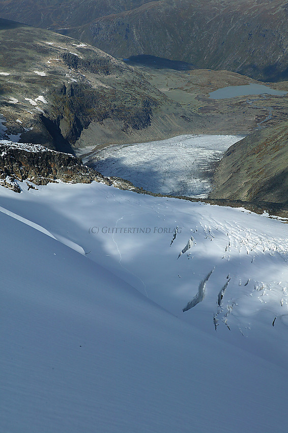 Høyt oppe på Gjertvassbreen, nær Gjertvasskardet, med utsikt nordvestover ned breen, videre mot Styggedalsbreen, Svartefjellet og deler av Helgedalen.