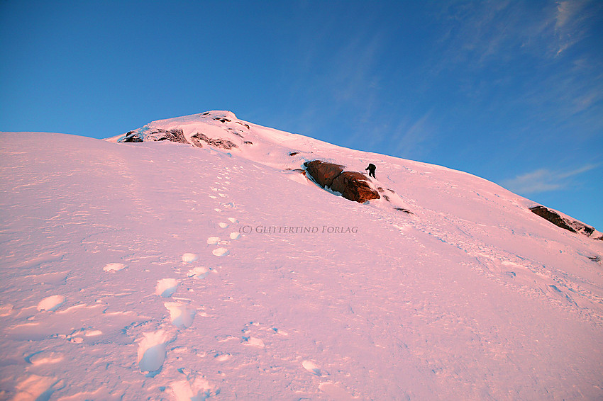 På vei opp den siste bratte snøbakken til Gjertvasstinden (2351 moh.) en maimorgen idet de første solstrålene råker fjellsiden.