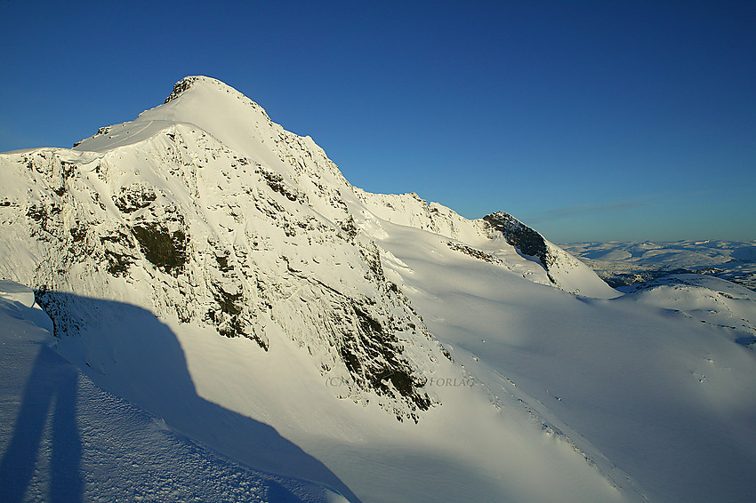 På østryggen nedenfor Gjertvasstinden (2351 moh.) med Gjertvassbreen nede til høyre. I bakgrunnen deler av Styggedals- og Skagastølsryggen. Nørdre Skagastølstinden (2167 moh.) med sort fjellvegg til høyre.