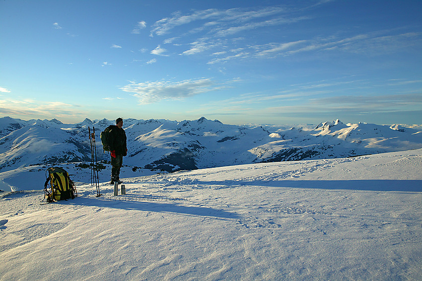 Like øst for Gjertvasstinden med sentrale og sørlige deler av Jotunheimen i bakgrunnen. Til høyre for personen ses bl.a. Uranostinden og helt til høyre i bildet dominerer Stølsnostinden.