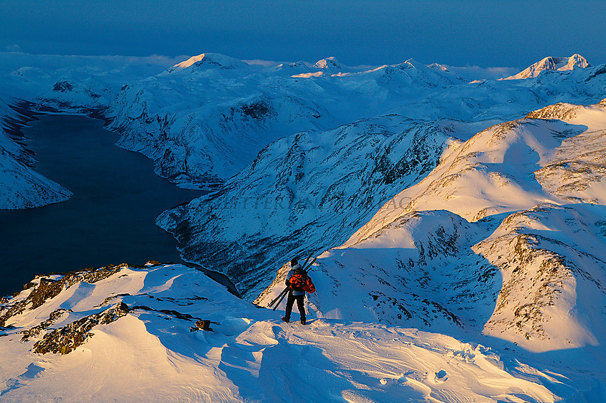 På vei ned Besseggen en vintermorgen med noen av Jotunheimens tinder badet i morgensol i bakgrunnen. 