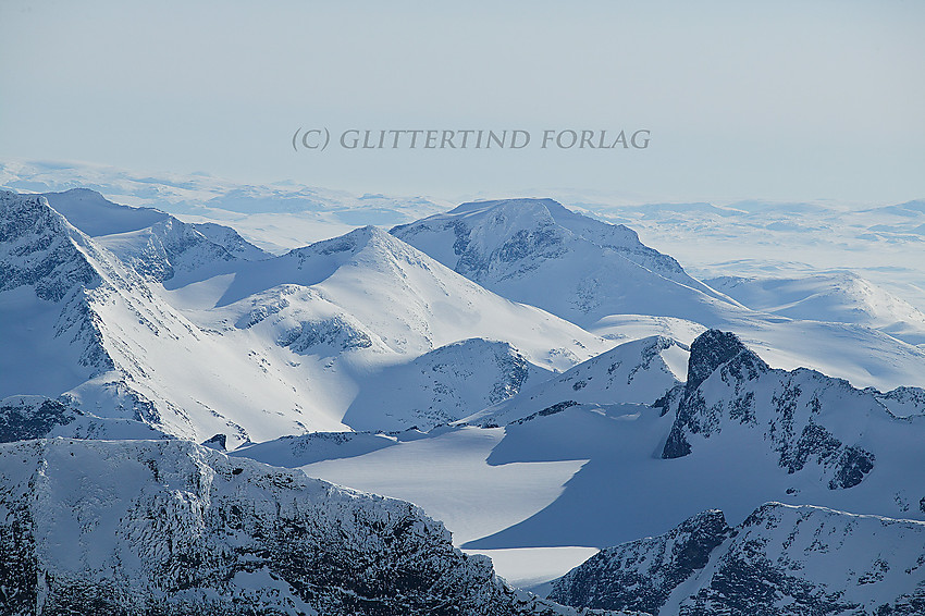 Utsikt i en sørlig retning fra Galdhøpiggen med telelinse. Store Bukkeholstinden (2213 moh.) er lett gjenkjennelig med Styggehøe i forgrunnen og Snøholstinden i bakgrunnen litt mot høyre.