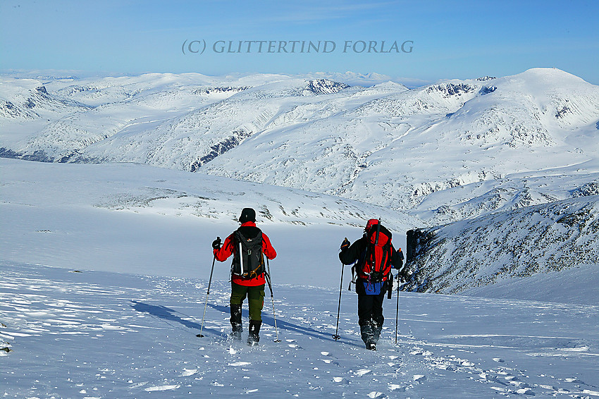 På vei ned fra Galdhøpiggen med Styggbrean nedefor. Bak til høyre ses Glittertinden og i det fjerne i midten kan Rondane skimtes.