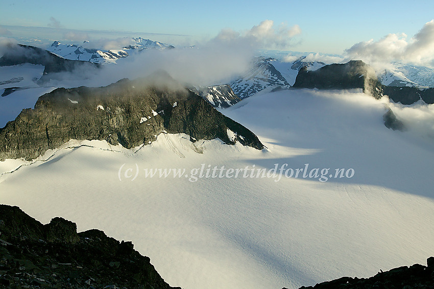 Utsikt i vestlig retning fra Galdhøpiggen en sommerkveld mot Storjuvtinden (2344 moh.) til venstre og Skardstinden (2373 moh.) lenger bak til høyre.