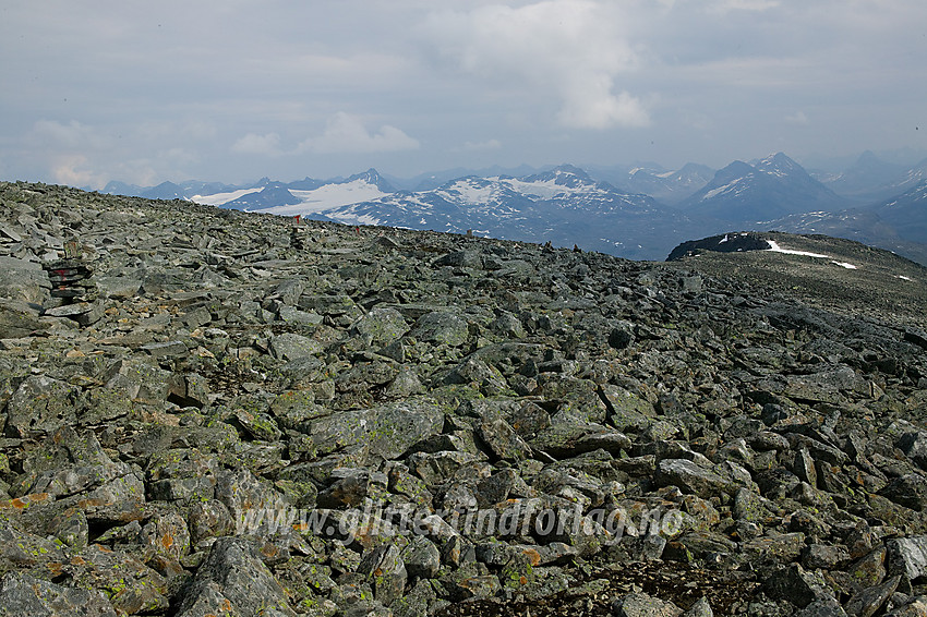 Fra Fannaråken mot Fannaråknosi og videre innover Jotunheimen. Vardene på rura mot Skogadalsbøen står tett i tett, slik at man ikke mister ruta i tåke, som det ofte er her oppe, for i nord lurer stupet ned mot Fannaråkbreen.