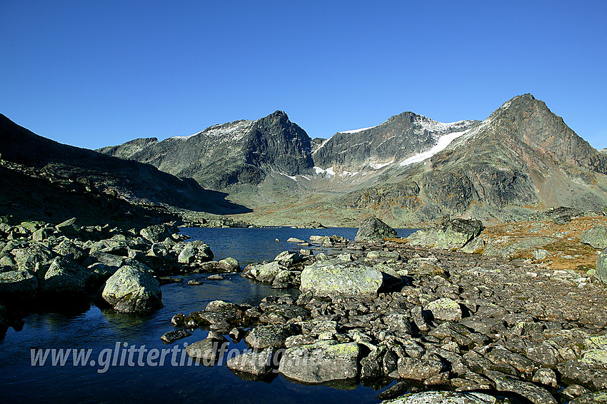 Ved utløpet av Galdbergtjernet. I bakgrunnen ses Slettmarkpiggen (2164 moh) og Slettmarkhøe (2190 moh). Stien mellom Eidsbugarden og Torfinnsbu krysser utløpet på bildet der steinene nesten har "vokst sammen".