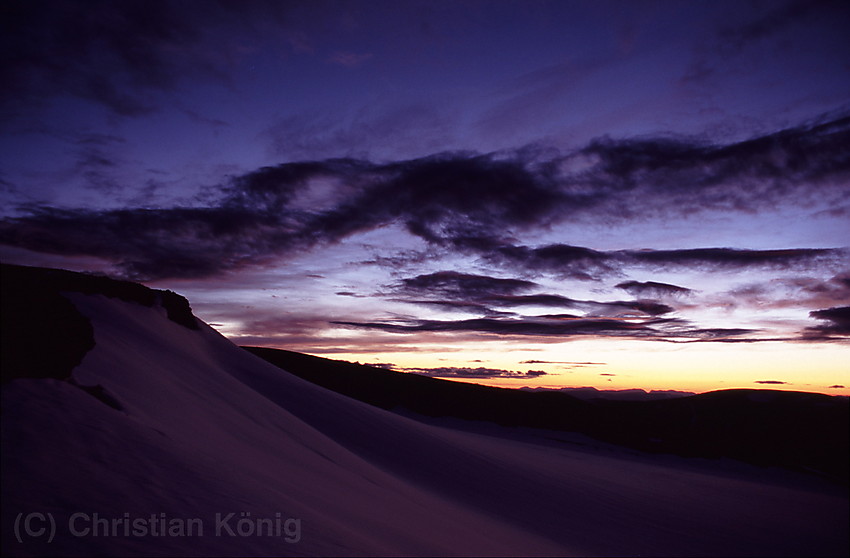 On the way to Glittertinden at nighttime having a break where the path gets close to Gråsubrean. It is still two hours until the sun will rise above the horizon.