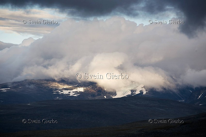 From Trollsteinkvelven valley towards Nautgardstindene obscured by clouds. Jotunheimen National Park. Norway.