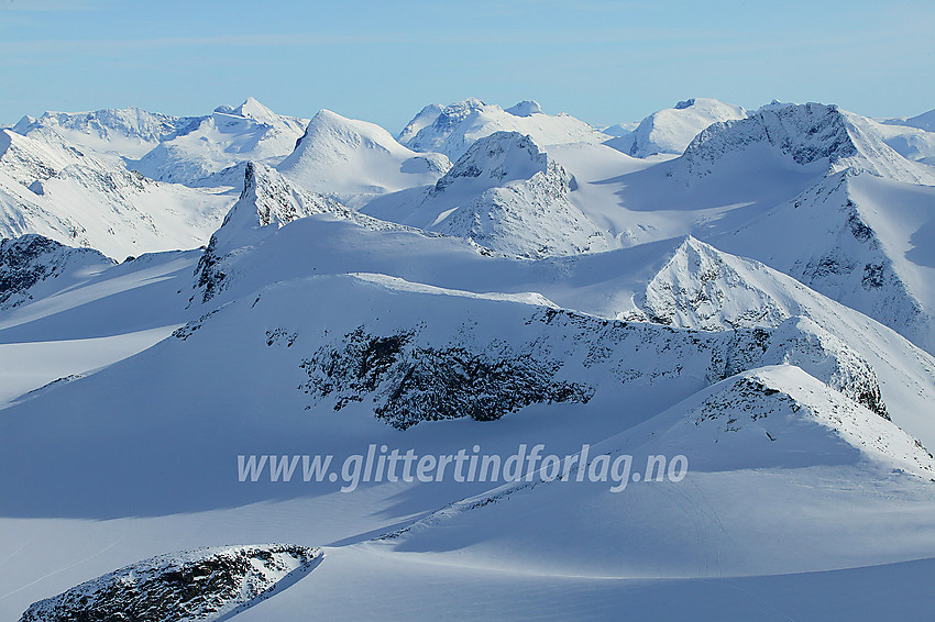 Utsikt fra Bukkehøe (2314 moh) mot Bukkeholstinane som ligger på rekke og rad: Bukkeholstinden nordøst for V3, V3, V2, V1, Midtre Vest, Midtre Øst og Store. I bakgrunnen ses bla.a. (f.h.m.v.) Visbreatinden, Semelholstinden og Semeltinden.