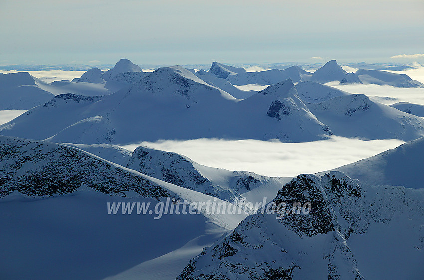 Utsikt fra Bukkehøe (2314 moh) sørvestover mot Store (2157 moh) og Vestre Rauddalstinden (2059 moh), som hever seg over tåkehavet. Fremst til høyre stikker Vestre Tverrbottinden (2113 moh) med sine to toppunkt opp.