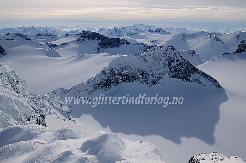 Flatt og mykt vinterlys over Jotunheimen. Fra Galdhøpiggen mot sørvest, med bl.a. Storjuvtinden (2344 moh) sentralt og Bukkehøe (2314 moh) bak denne.