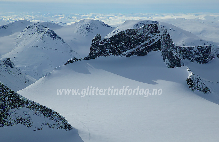 Fra Galdhøpiggen (2469 moh) mot Skardstinden (2373 moh) med Nåle, Søraustre Skardstinden og Heimre Søre Illåbreatinden. Bakenfor ses bl.a. (f.v.m.h.) Skagsnebbene, Veslfjelltinden og Loftet.