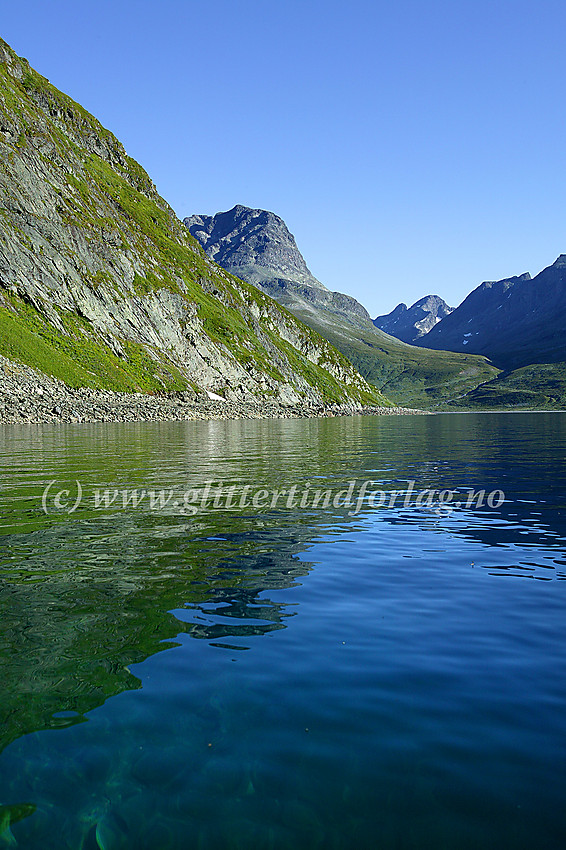 På padletur langs Bygdins sørbredd, her innunder Grøneberget med Grønebergodden forut. I bakgrunnen bl.a. Torfinnstindane, Torfinnsdalen og Vestre Leirungstinden.