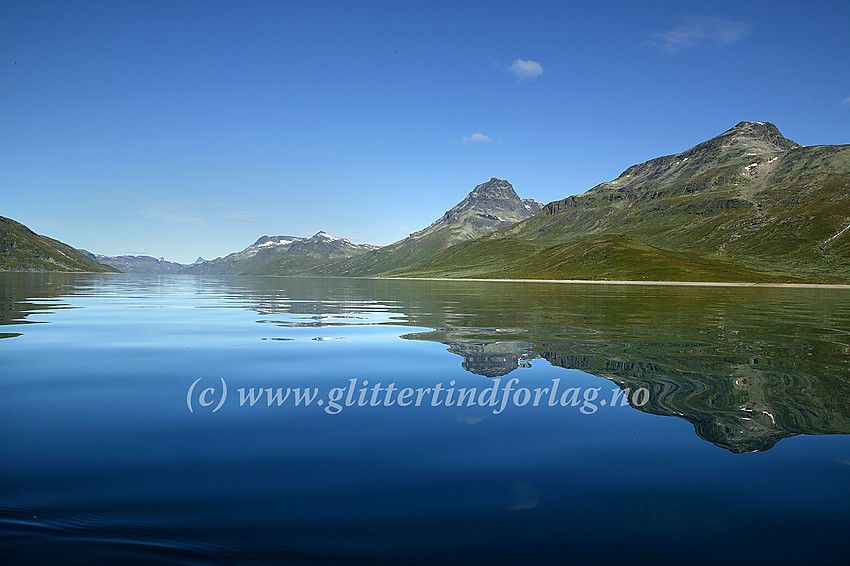 Padling på Bygdin en blikkstille sommerdag. Her er det bl.a. Torfinnstindane (2119 moh) og Nørdre Kalvehølotinden (2019 moh) som speiler seg.