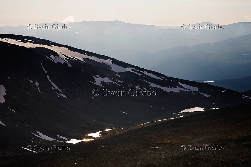 Looking down into Smuiugjelholet valley from Svartholshøe with Breheimen mountain area behind. Jotunheimen National Park. Norway.