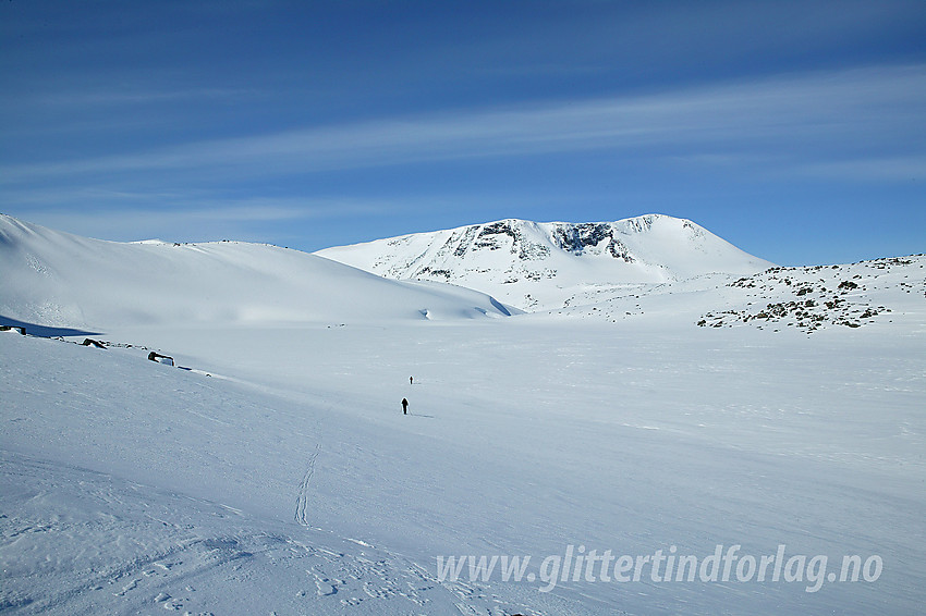 Skiløpere på vei over Grøntjørni på sin vei mot Holåtindane. I bakgrunnen ses Tundradalskyrkja (1970 moh).