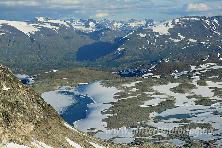 Fra Vest for Midtre Hestbreapiggen (M2, 2143 moh) sørover mot skillet mellom Bøver- og Leirdalen med Loftet (2170 moh) som den dominerende såteformede toppen til høyre. I bakgrunnen ses bl.a. Bukkehøe til venstre og Tverrbottindane i midten. Foran til venstre bak fjellsiden mot platået på Midtre Hestbreapiggen ligger Høybreavatnet, delvis islagt.