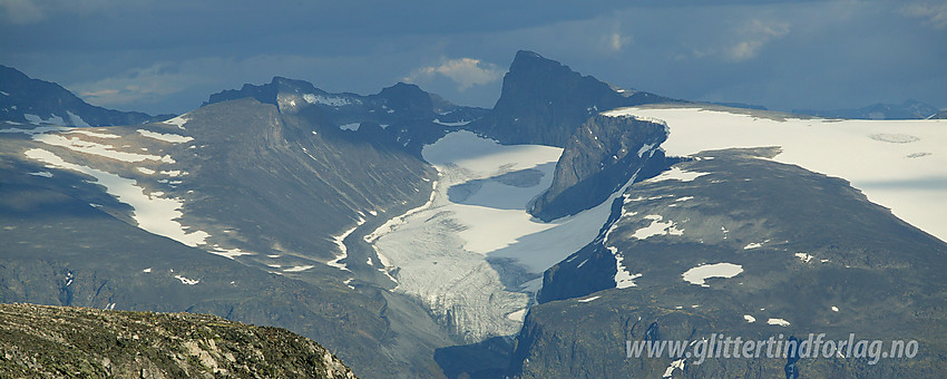 Fra Vest for Midtre Hestbreapiggen (M2, 2143 moh) sørover mot Heimre Illåbrean og Skardstinden (2373 moh), sistnevnte med Dumhøeplatået og Dumhøebrean foran til høyre. Til venstre er Bakarste Storgrovhøe opplyst av sola.