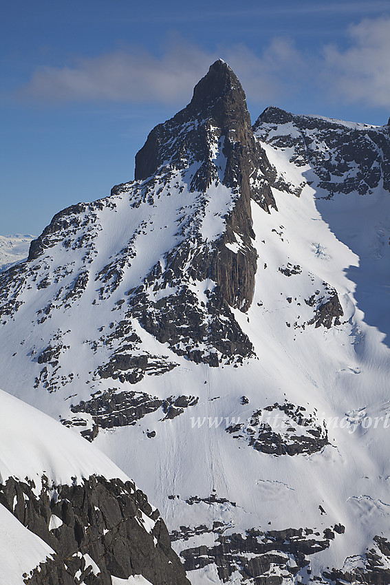 Store Skagastølstinden (2405 moh) sett fra Vetle Midtmaradalstinden. Ganske langt nede til venstre ses en tynn hvit stripe på tvers over en fjellskrent. Dette er Berges Chaussée.