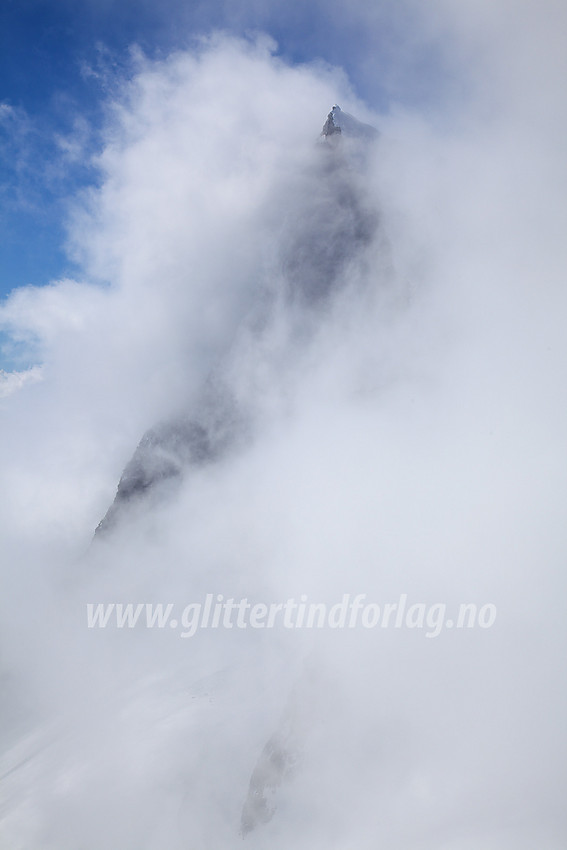 Store Austanbotntinden (2204 moh) og tåkeskyene. Bildet er tatt fra en skulder like nedenfor Store Ringstinden.