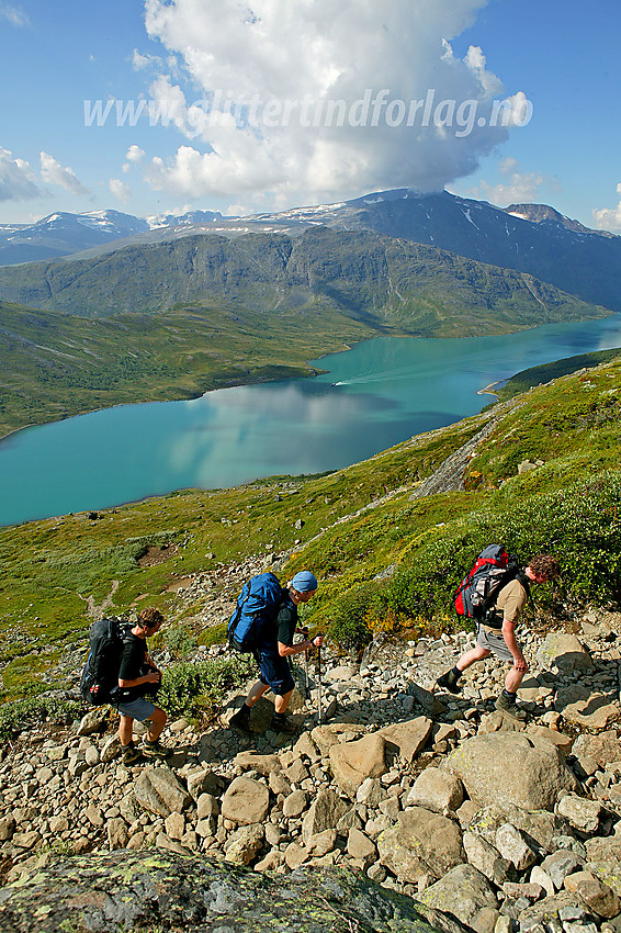 Fjellvandrere med kurs mot Besseggen. Her på vei opp fra Gjendesheim mot Veslfjellet. I bakgrunnen Gjende og Knutshøe videre innover i Gjendealpene.