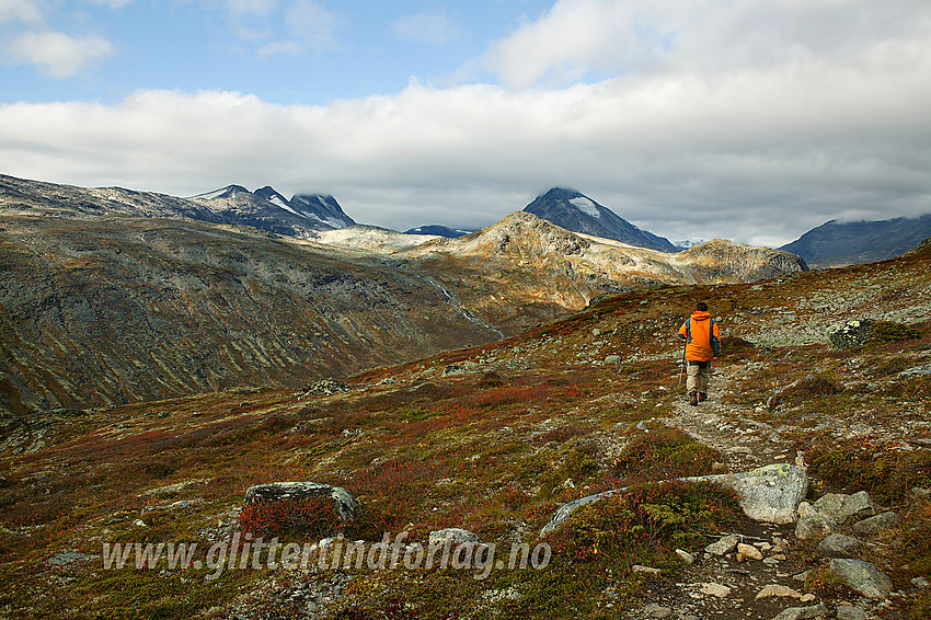 Fjellvandrer på vei fra Memurutunga over mot Storådalen. I bakgrunnen ses bl.a. Hellerkampen og Skarddalseggje (2159 moh).