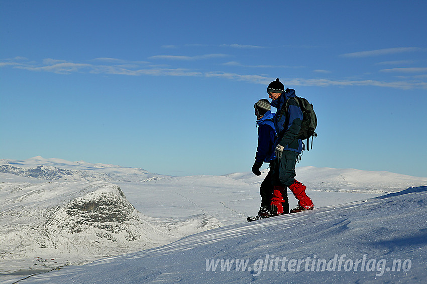 Turgåere i ivrig prat på vei ned fra Bitihorn en strålende høstdag. I bakgrunnen bl.a. Synshorn og Valdresflye.

