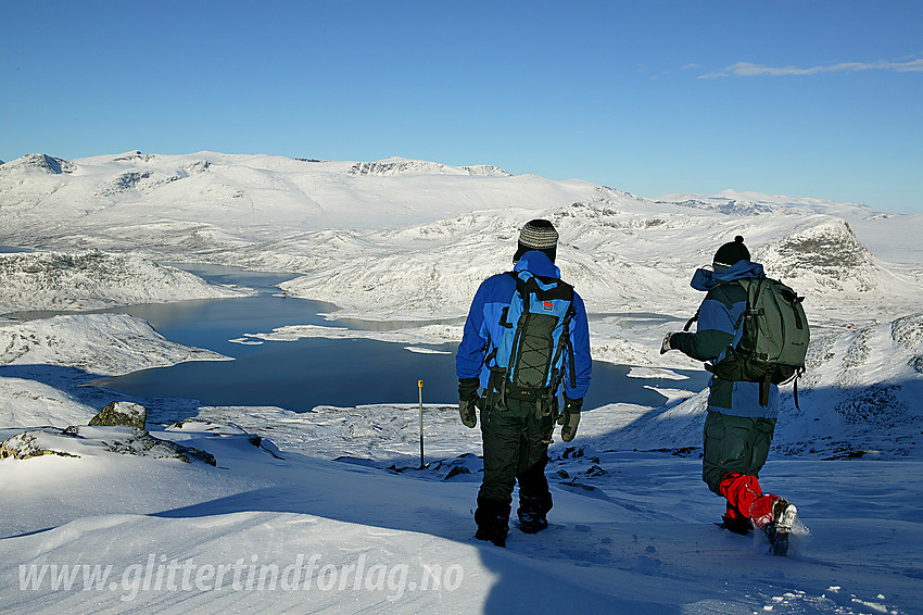 Fjellvandrere på vei ned fra Bitihorn med Raudfjorden / Bygdin og Gjendealpene i bakgrunnen.