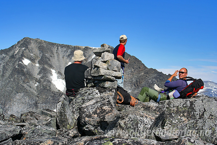 Pause på toppen av Storjuvtinden (2344 moh) med Galdhøpiggen i bakgrunnen.