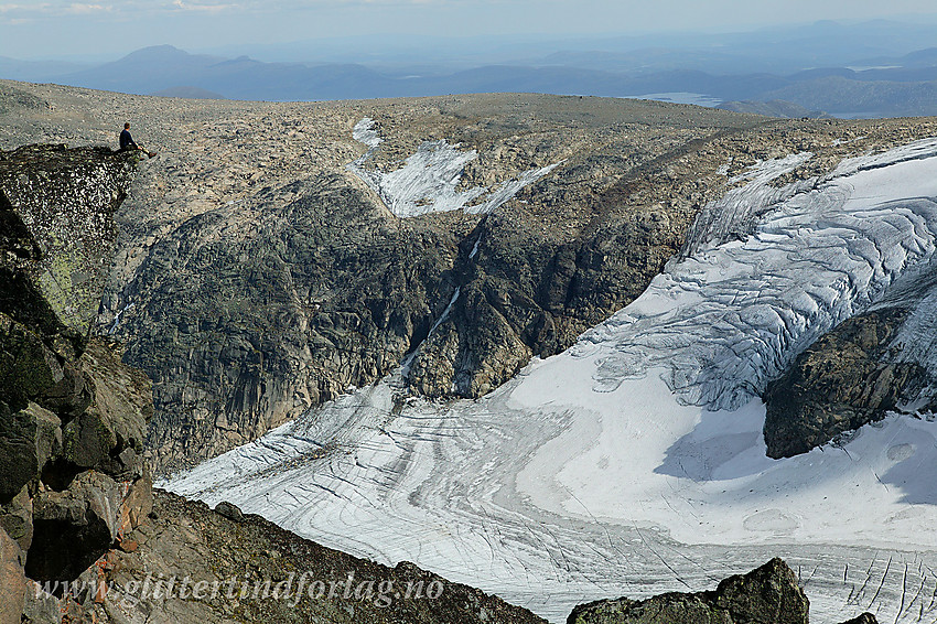 Luftig utsiktsklippe på ryggen mellom Munken og Mugna. I bakgrunnen "Steindalsbreen" og den vesle kulen sørvest for Rasletinden.