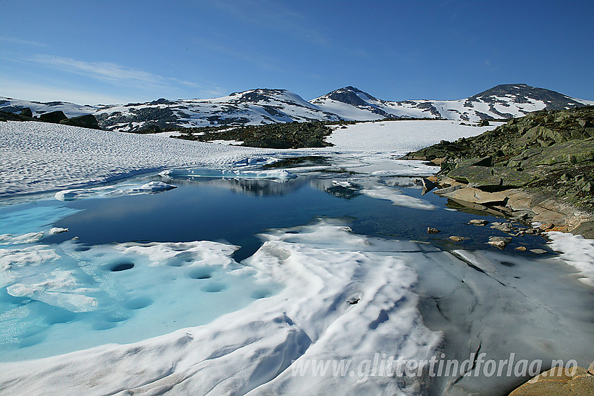 I Breidalen ved et idyllisk isvann med Holåtindane i bakgrunnen.