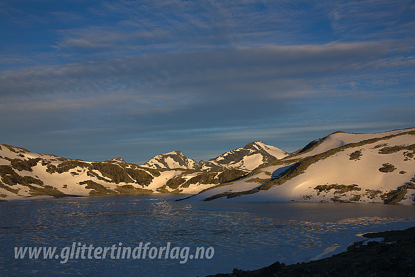 Ved Hinnåtetjønne en sommermorgen. I bakgrunnen, badet i morgensol, ses fra venstre: Store Rauddalseggje (2168 moh) og Skarddalseggje (2159 moh).