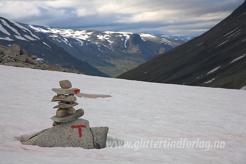 Nær Urdadalsbandet med varde og rød T som viser vei ut på snøfonna. I bakgrunnen skimtes Visdalen.