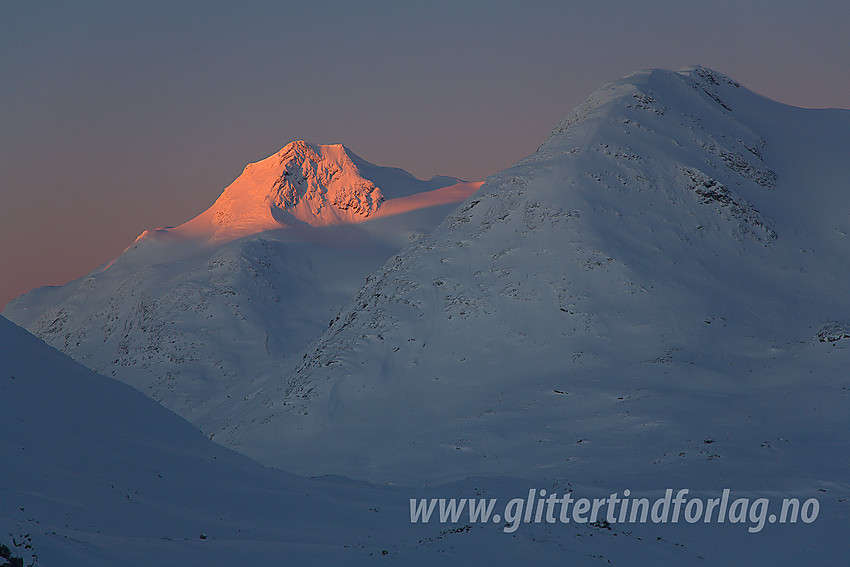 Gravdalstinden (2113 moh) i soloppgang sett fra øst-sørøst. Til høyre ses Surtningstinden (1997 moh), men sola har ennå ikke nådd dit.