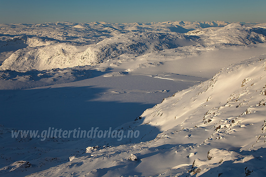 Like ved Berdalseken med utsikt ned på det islagte vannet like sør for toppen. På kartene har det gjerne vært markert med bre her, men breen/fonna slutter i vestenden av tjernet.