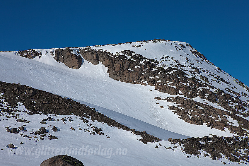 På Raslet med Øystre Rasletinden (2010 moh) i bakgrunnen. Legg merke til alle skisporene på den vesle breen og den vesle skiløperen som er på vei oppover.