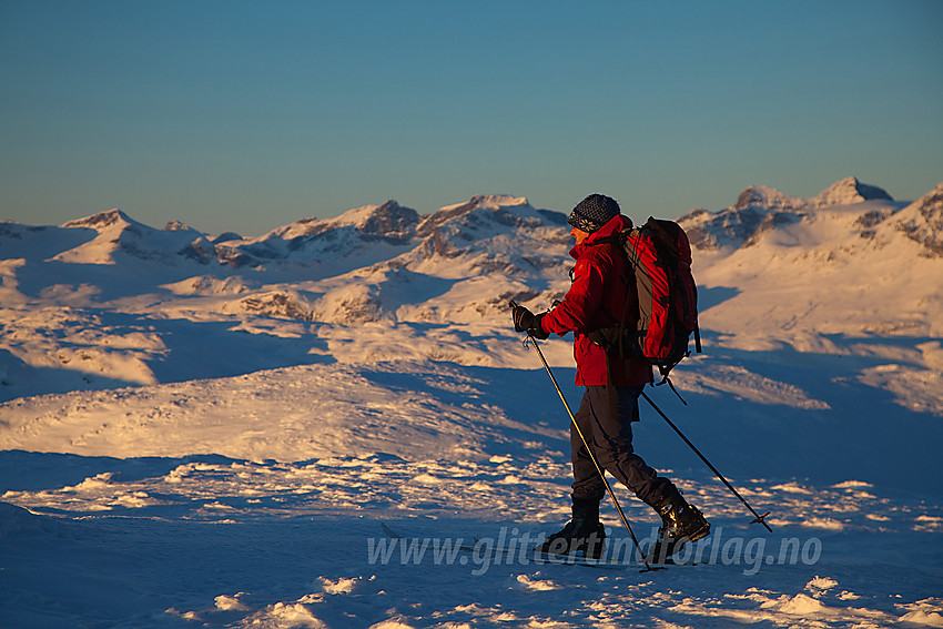 Skiløper på toppen av Mugnetinden (1737 moh) i Vang. Gjendealpene i Jotunheimen ses i bakgrunnen.