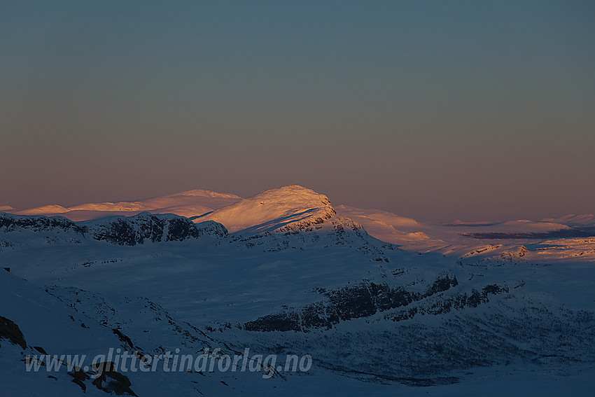 På vei ned fra Mugnetinden med utsikt til Bitihorn i solnedgang.