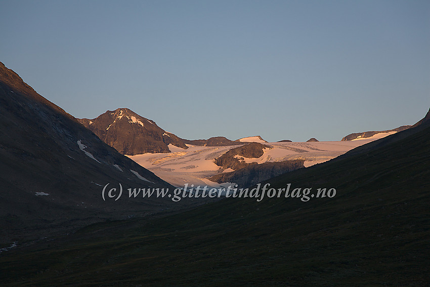 På stien oppover Visdalen fra Spiterstulen en tidlig sommermorgen med utsikt vestover mot Tverråbren og Nørdre Bukkeholstinden (2149 moh., til venstre).