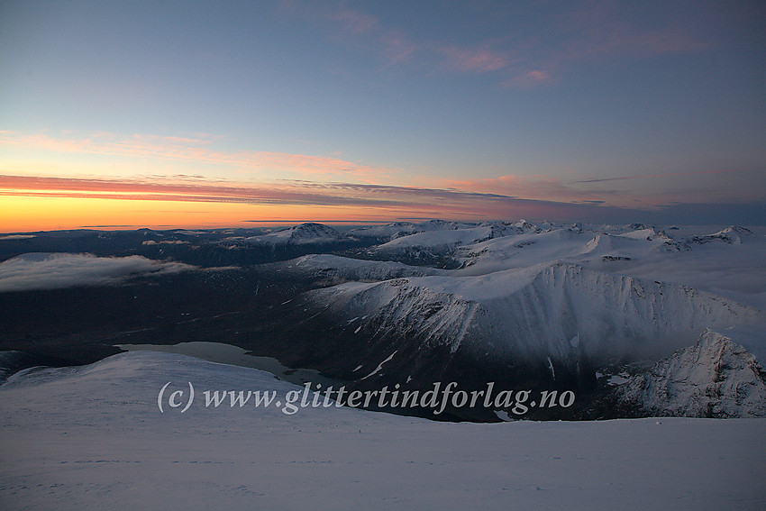 Morgengry over østlige deler av Jotunheimen sett fra Glittertinden en høstmorgen. I forgrunnen deler av Steinbuvatnet og Ryggjehøe.