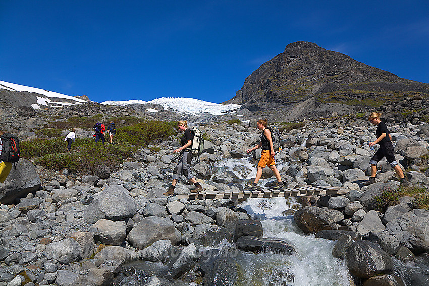 Svellnosbreagrove krysses på liten bro. Breen ses i bakgrunnen.