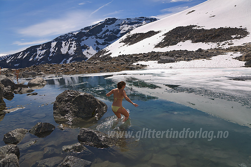 Isbading i lite tjern oppe ved Svellnosbrean en varm sommerdag. I bakgrunnen ses Styggehøe (2213 moh).