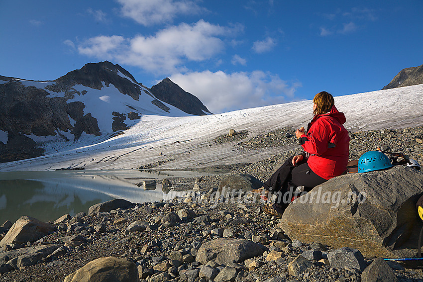 Pause på en stein blant morenegrus nedenfor Uranosbreen. I bakgrunnen ses Uranostinden S2 (2048 moh) og Uranostinden (2157 moh).