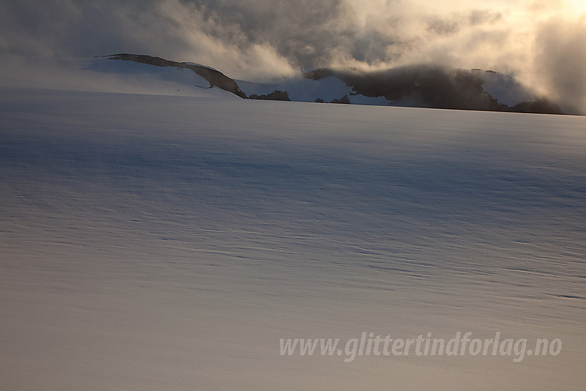 Stemningsfullt på retur fra Lodalskåpa med breflata i forgrunnen. Fjellet i bakgrunnen er den 1819 meter høye toppen vest for Bohrsbreen.