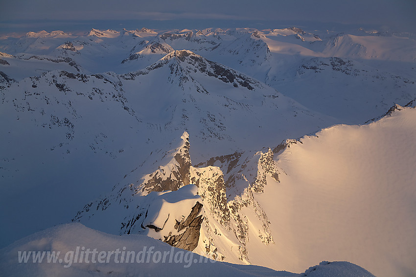 Fra Store Hellstugutinden en aprilmorgen med nordryggen i forgrunnen og Jotunheimens tindehav i bakgrunnen.