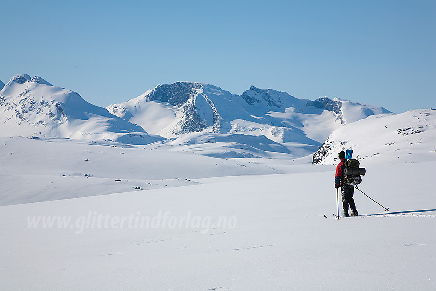 Skiløper på vei ned Vestre Memurubre med Gjendealpene i bakgrunnen.