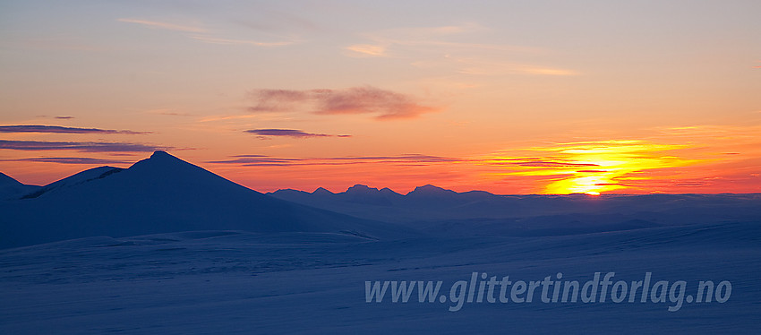 Morgenstund på Sutrningssuoksle mot Nautgardstindens silhuett. I det fjerne ses omrisset av Rondane.