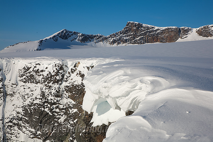 Ved stupkanten øst for Surtningssubrean med Midtre Surtningssue (2251 moh) og Surtningssue Sørtoppen (2302 moh) i bakgrunnen.