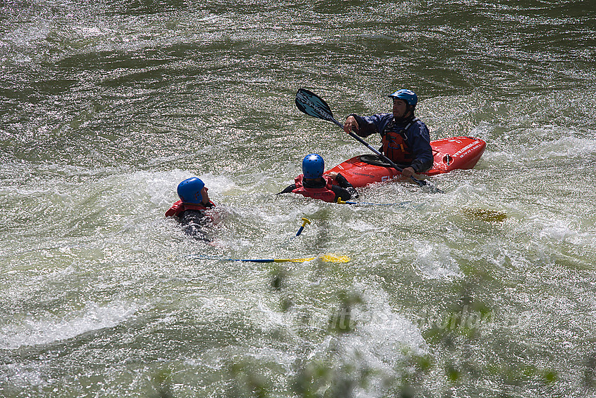 Rafting og padling i Sjoa nedenfor Heidal. Her hjelpes raftere  av hjelpeguider etter at flåten deres veltet.