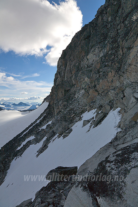 Ved å følge fjellsiden oppunder bergveggen snaut 100 meter bortover her, får man en teknisk sett relativt enkel omgåelse av den bratte hammeren øst for Storjuvtinden.